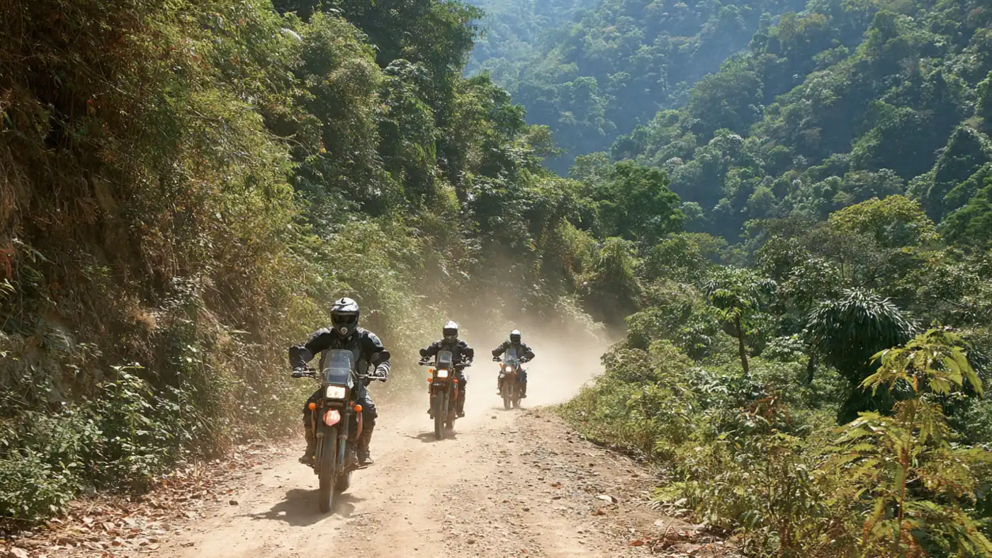 Enduro riders kicking up dust on a jungle dirt road