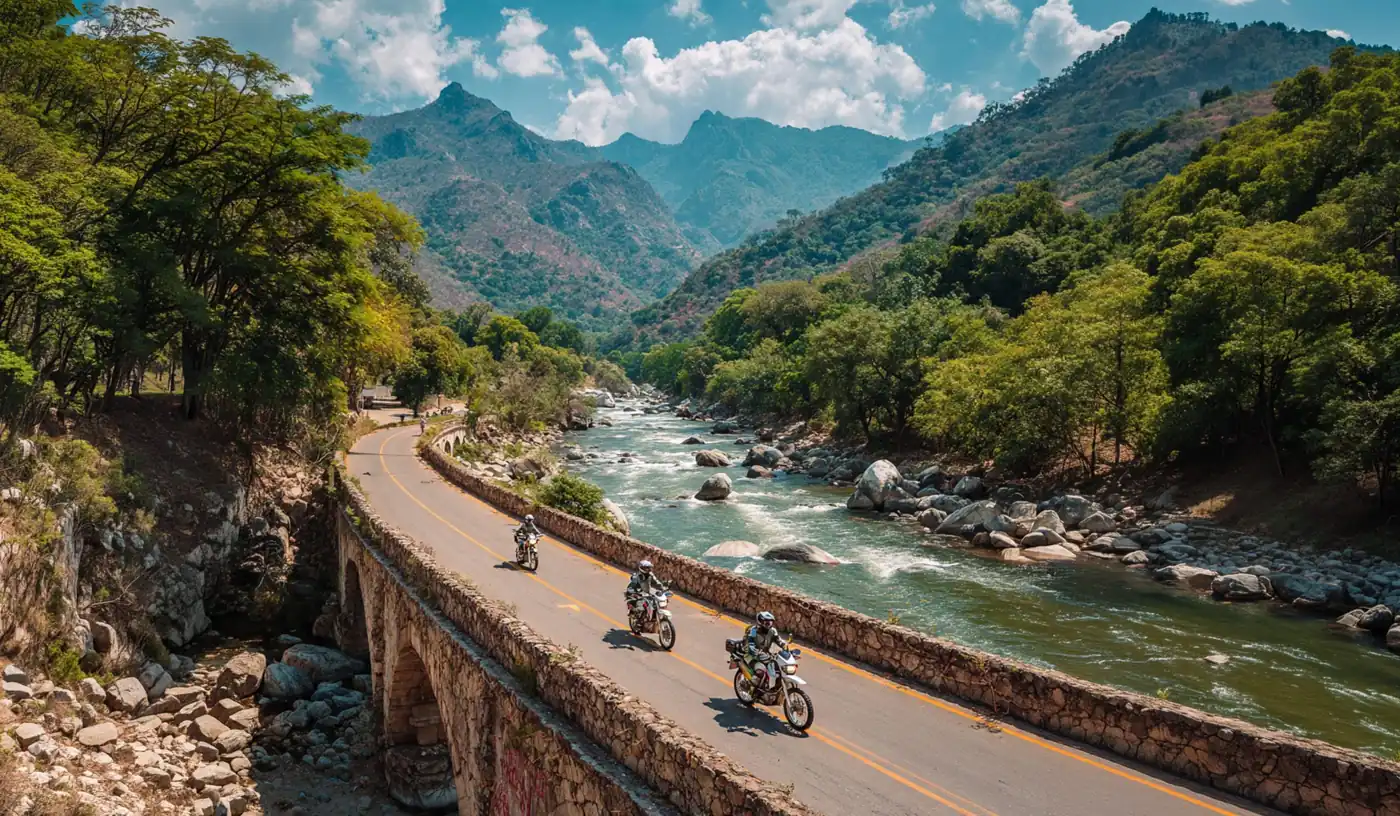 Riders on a stone bridge road beside a mountain river